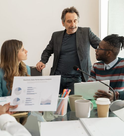 Multicultural team engaged in business analytics discussion - lively collaboration in a modern office setup - showcasing teamwork and strategy planning.